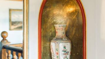 Un vase décoratif orné de motifs floraux, posé sur une étagère.