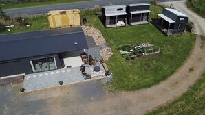 A modern house with a large garage, a paved driveway, and a small garden area.