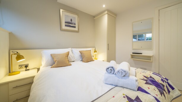 A neatly made bed with a quilt, a bedside lamp, and a framed picture on the wall. - The Viewpoint -  Central Ambleside and short stroll to shops, cafes (Ambleside)