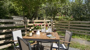 A wooden table with chairs, a wine bottle, glasses, and a book. - Cringlemire Farm Cottage -  17th century cottage that sleeps 4 guests  in 2 bedrooms (Bouth)