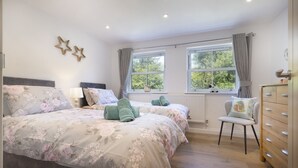 A bedroom with two beds, a dresser, a chair, and two windows with curtains. - Cringlemire Farm Cottage -  17th century cottage that sleeps 4 guests  in 2 bedrooms (Bouth)