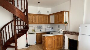 A kitchen with wooden cabinets, a white refrigerator, a microwave, and a stove.