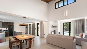 Een moderne, open woonruimte met keuken, eethoek en zithoek.
