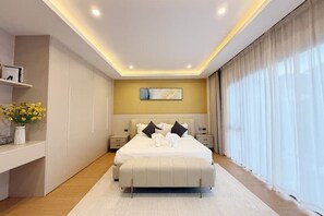Een moderne slaapkamer met een groot bed, nachtkastjes, een wanddecoratie en een raam met gordijnen.
