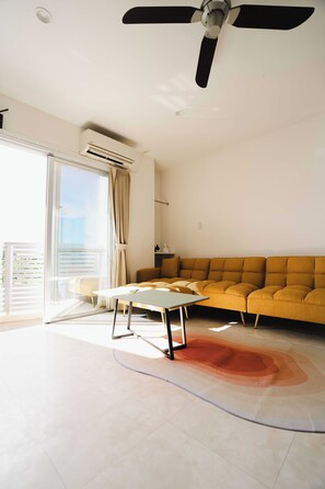 Habitación familiar, balcón, vista a la bahía | Área de sala de estar