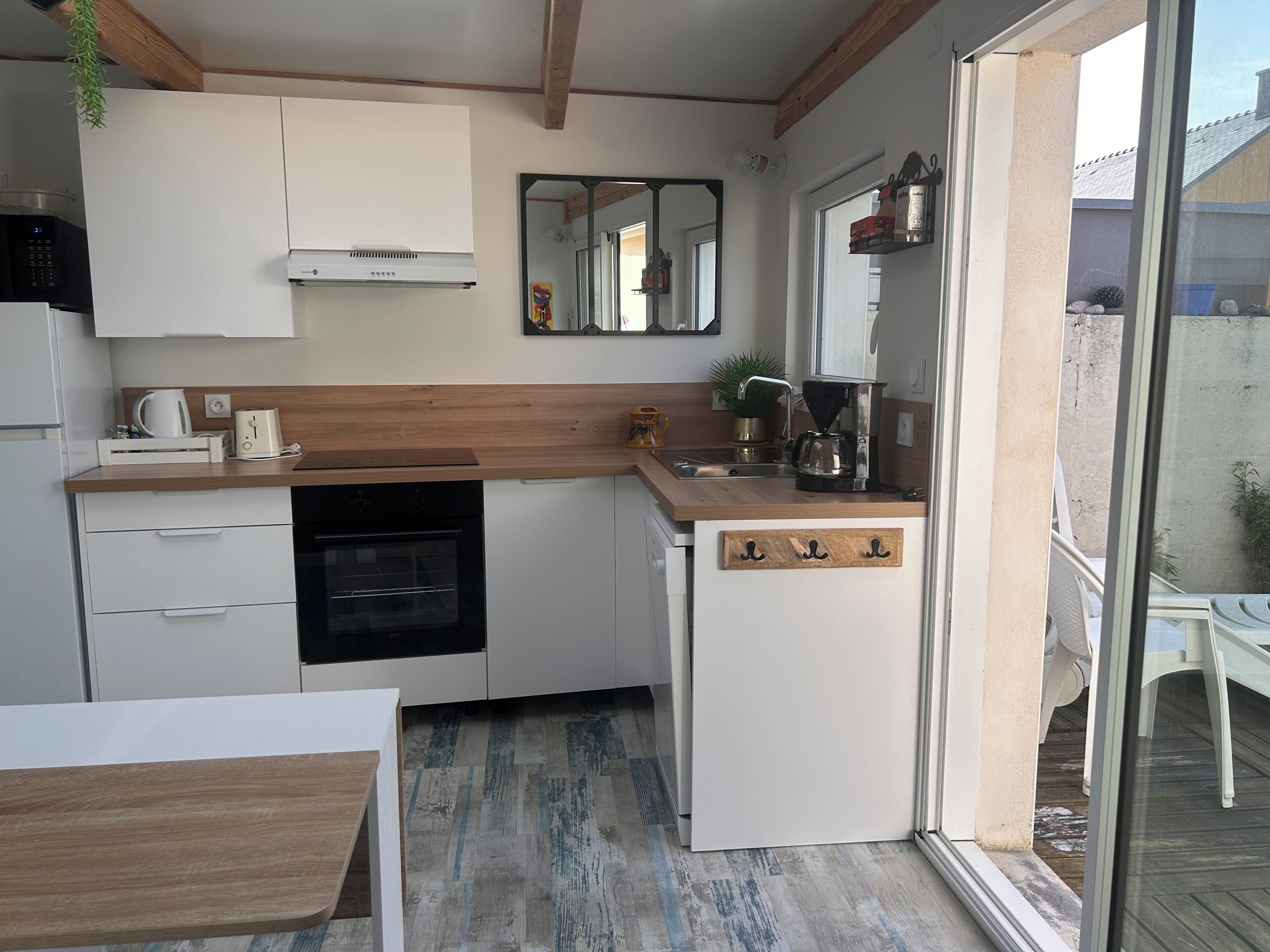 A compact kitchen with a built-in oven, a coffee maker, and a small sink.