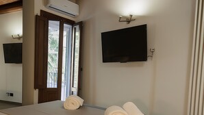 Een hotelkamer met een groot bed, een flatscreen-televisie aan de muur en een raam met uitzicht.