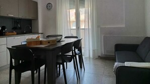 A compact living space with a kitchenette, dining area, and a sofa.