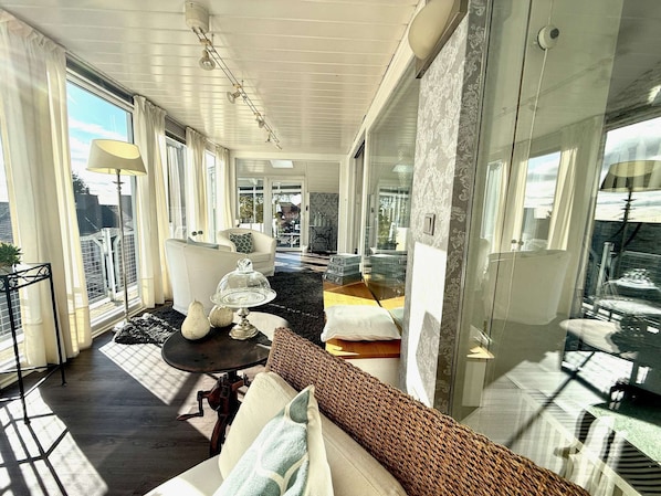 Een ruim balkon met een bank, een tafel met decoratieve objecten en uitzicht op de stad.