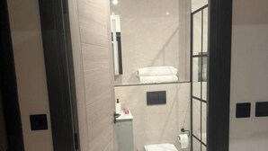 A modern bathroom with a toilet, sink, and towel rack. - Luxury and Spacious 1BR Flat Sleeps 4 with Private Patio I Excellent Location (London)