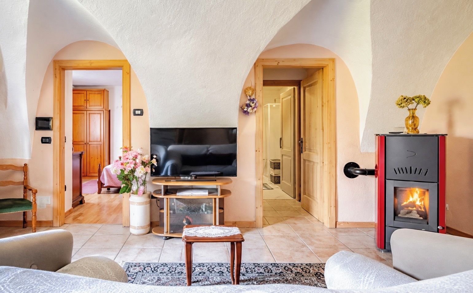 A cozy living room with a television, a fireplace, and a dining area with a table and chairs.