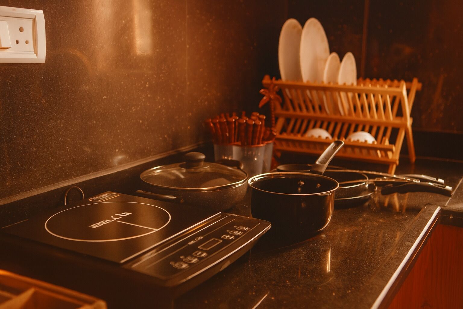 A kitchen with a stove, pots, and a dish rack.