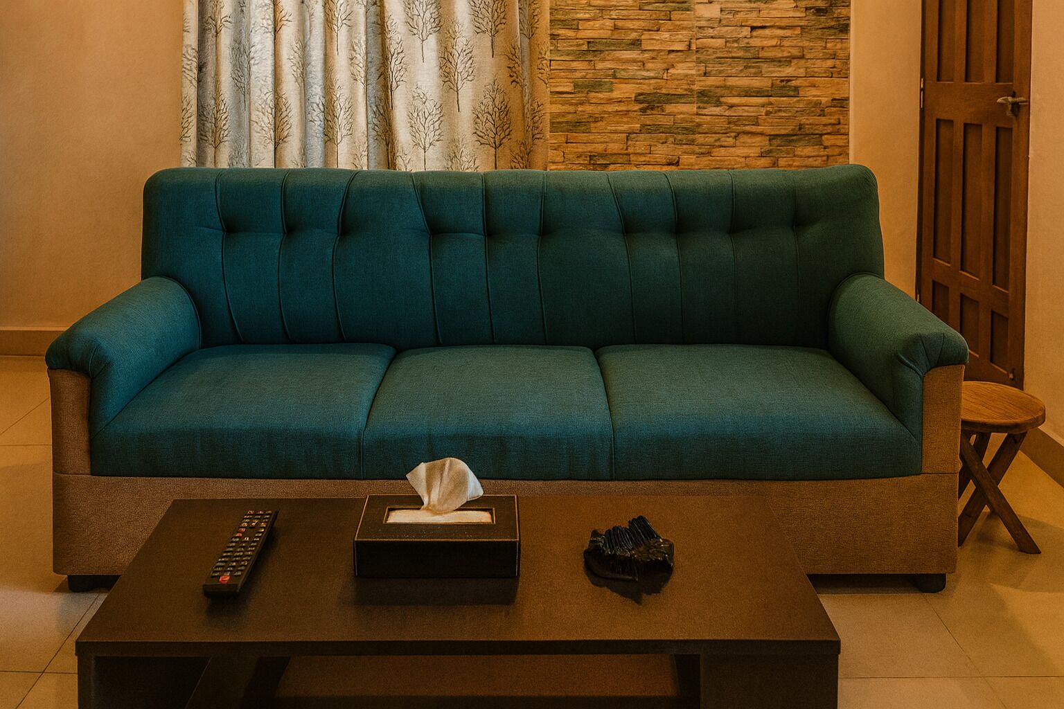 Ein türkisfarbenes Sofa in einem Wohnzimmer mit Fernbedienung und Taschentüchern auf einem Couchtisch.