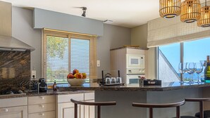A modern kitchen with a marble countertop, a bowl of fruit, and a view of the sea. - Holiday home 4 ppl - Sea view & beach access - Sarzeau (Sarzeau)