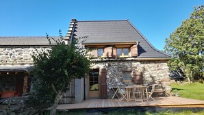 A stone house with a wooden deck and outdoor seating. - Renovated cottage for 4 pers. with equine accommodation, Saint-Front (Saint-Front)