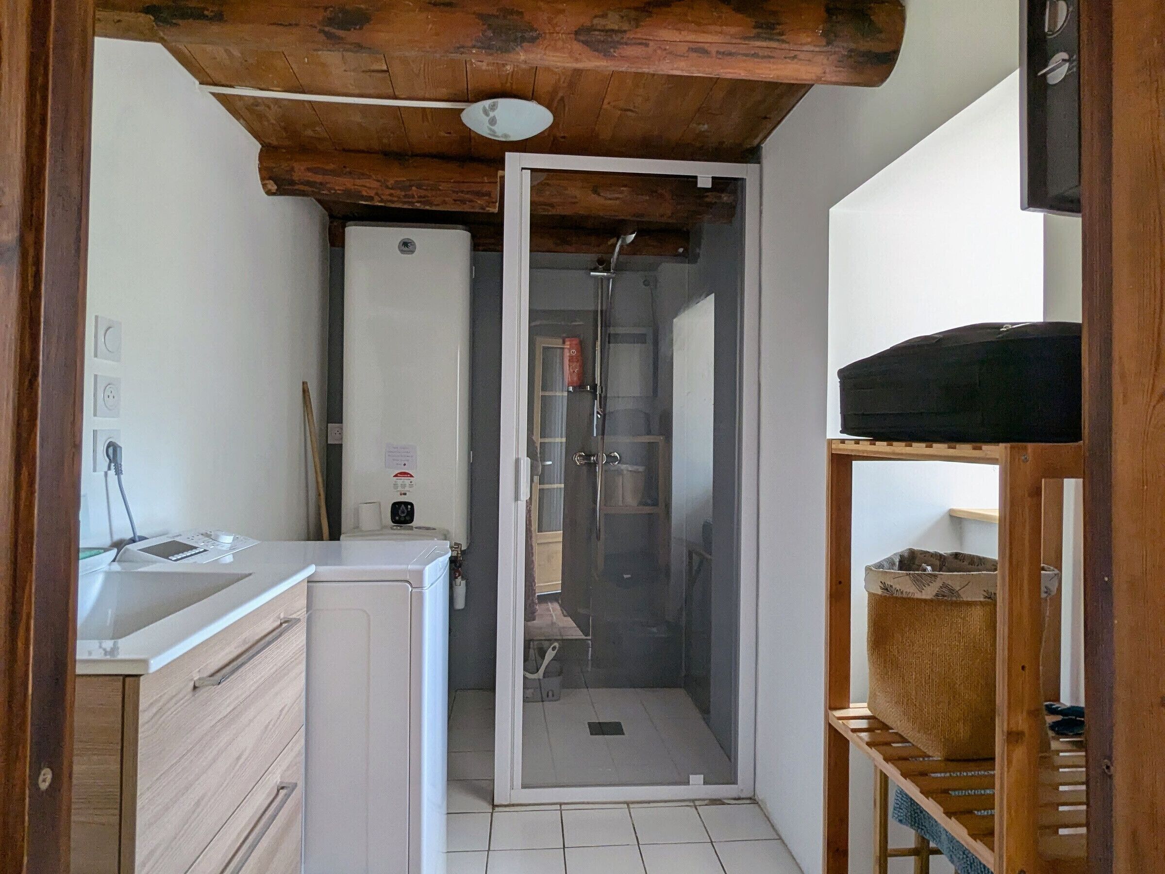 A compact bathroom with a shower enclosure, a toilet, and a sink.