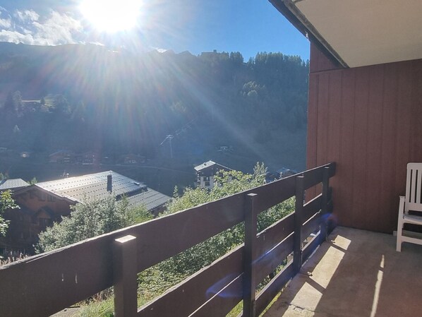 A balcony with a view of a village and mountains. - Bright apartment near slopes, pool access, pets allowed (La Plagne 1800)