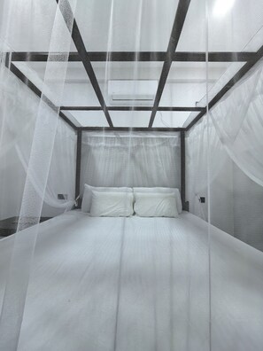 Una cama con dosel y cabecera de diseño geométrico.