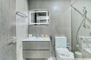 Estudio exclusivo, balcón, vista a la ciudad | Baño | Regadera, secadora de cabello, toallas, jabón