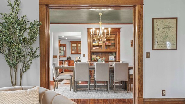 A dining area with a wooden table and chairs, a chandelier, and a map on the wall. - Walk Downtown + Hot Tub + Sauna + Game Room + Pets (Wisconsin Dells)