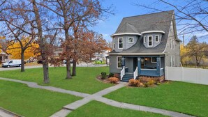 A two-story house with a front porch, a driveway, and a lawn. - Walk Downtown + Hot Tub + Sauna + Game Room + Pets (Wisconsin Dells)