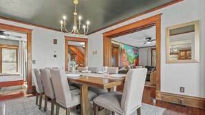 A dining room with a wooden table, six chairs, and a chandelier. - Walk Downtown + Hot Tub + Sauna + Game Room + Pets (Wisconsin Dells)