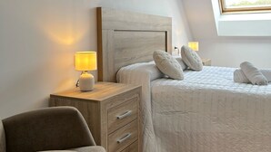 Een slaapkamer met een bed, nachtkastjes, een lamp en een raam.