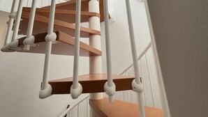 Een wenteltrap met witte balustrades en houten treden.