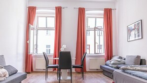 A modern room with a dining table, two chairs, a sofa, and a bed. - Spacious 5BR Apt Close to Augarten (Vienna)