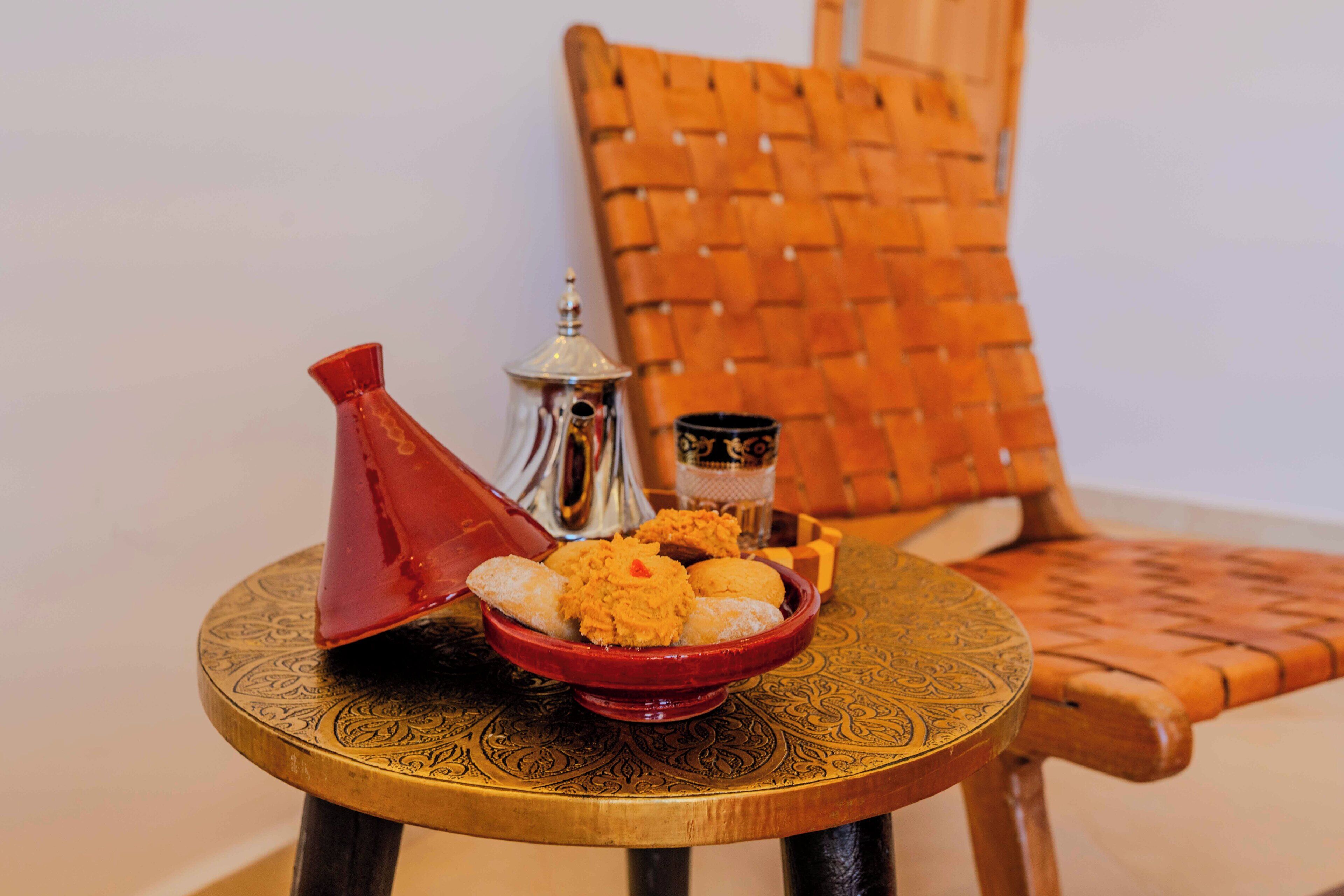Een tafel met een decoratieve schaal eten en een theepot.