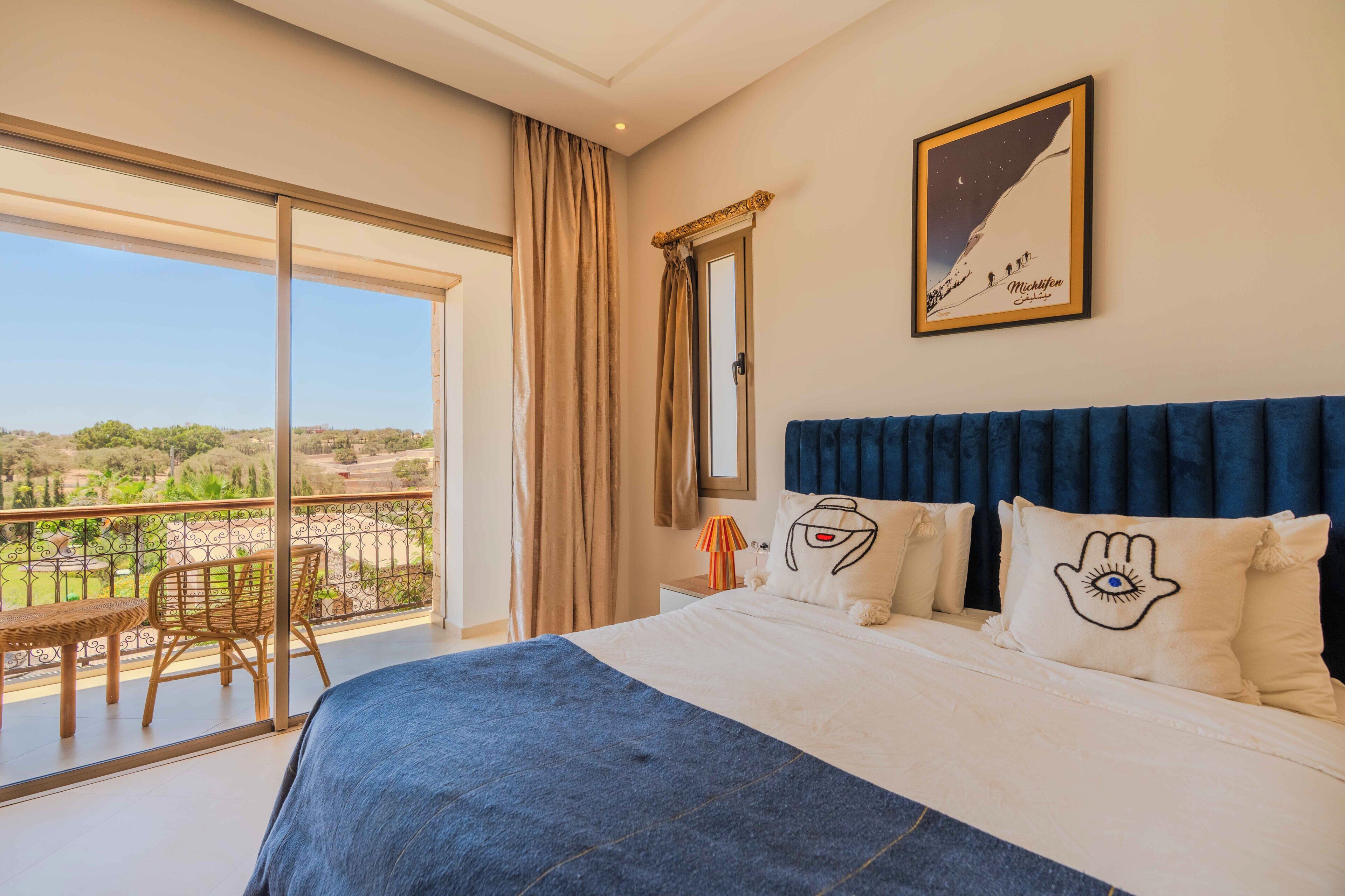 Ein Schlafzimmer mit einem großen Bett, einem Balkon mit Blick und einem gerahmten Bild an der Wand.