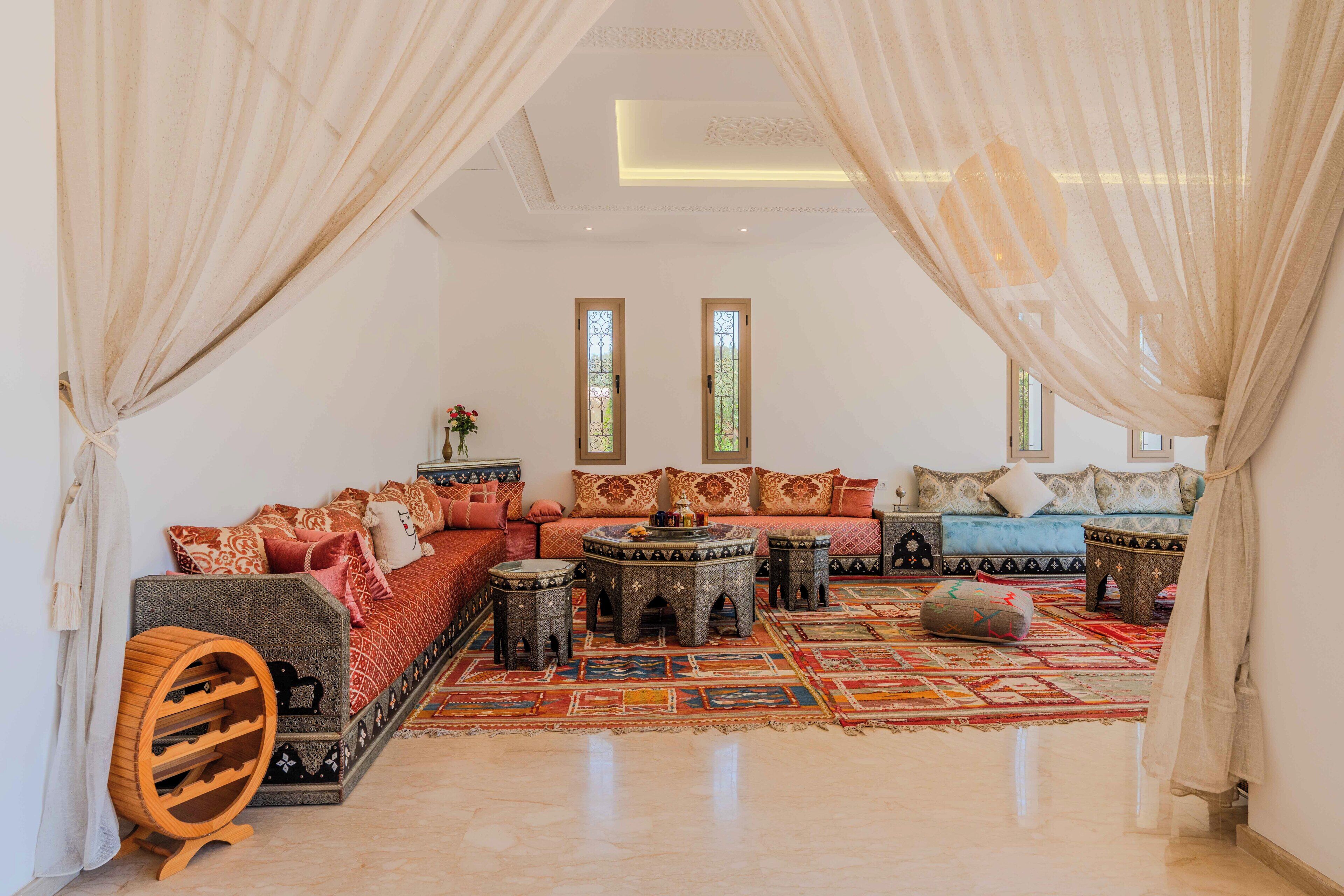 A spacious living room with a large sofa set, a coffee table, and a patterned rug.