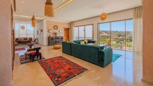 Un salón espacioso con un sofá grande, una chimenea y vistas al exterior.
