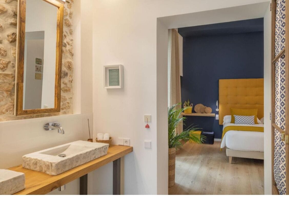 A bathroom with a stone sink, a mirror, and a small framed picture on the wall.