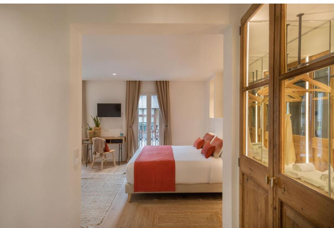 Una habitación de hotel con cama, escritorio y televisor.