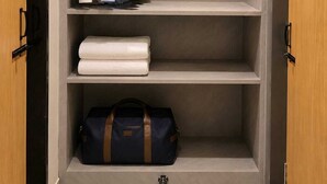A wardrobe with hanging clothes and a folded towel on the shelves. - Hotel Abhishek Pride  (Shani Shingnapur)