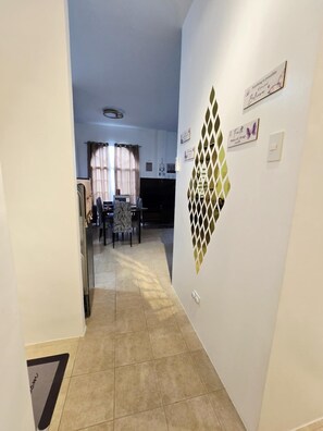 A narrow hallway with a tiled floor leading to a dining area with a table and chairs. - Comfort of Home in Panglao, Bohol.  Rest and enjoy our home while in the Island. (Dauis)