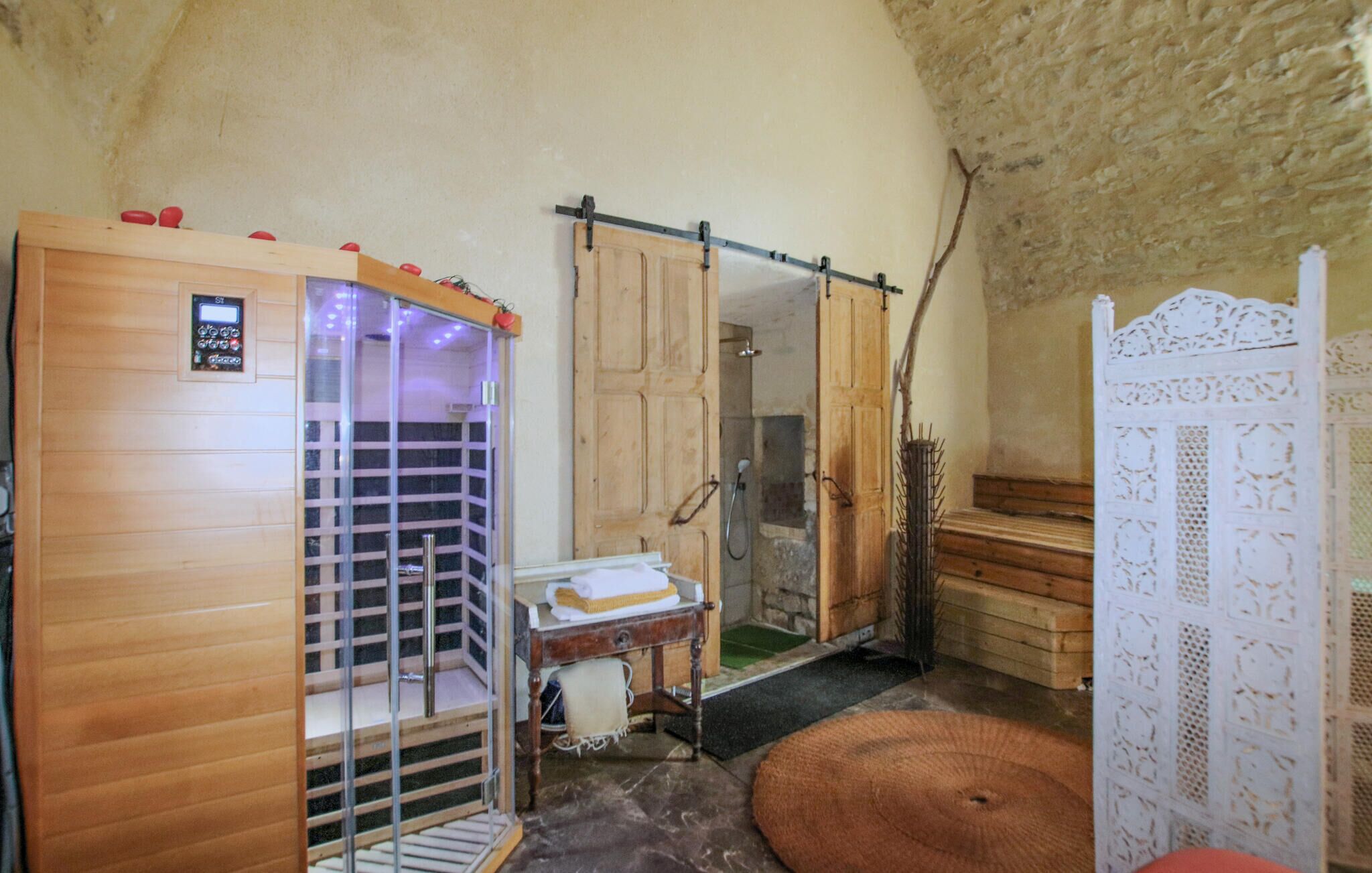 A sauna room with a wooden cabinet, a wooden bench, and a white decorative panel.