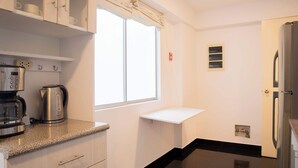 Eine moderne Küche mit Kaffeemaschine, Wasserkocher und Kühlschrank.