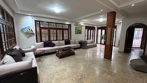 A spacious living area with a large sofa set, a coffee table, and a decorative column. - residence riad zitoune (Marrakech)
