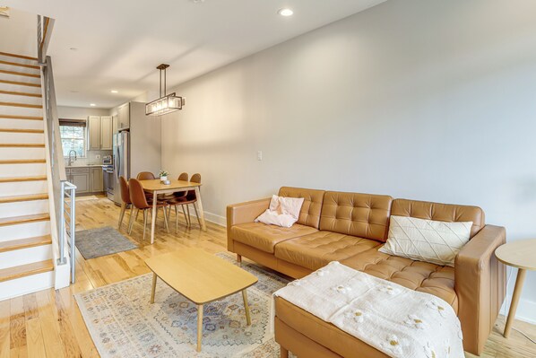 A modern living room with a sofa, coffee table, and dining area. - Philly Hub Near University City, Lincoln Financial (Philadelphia)