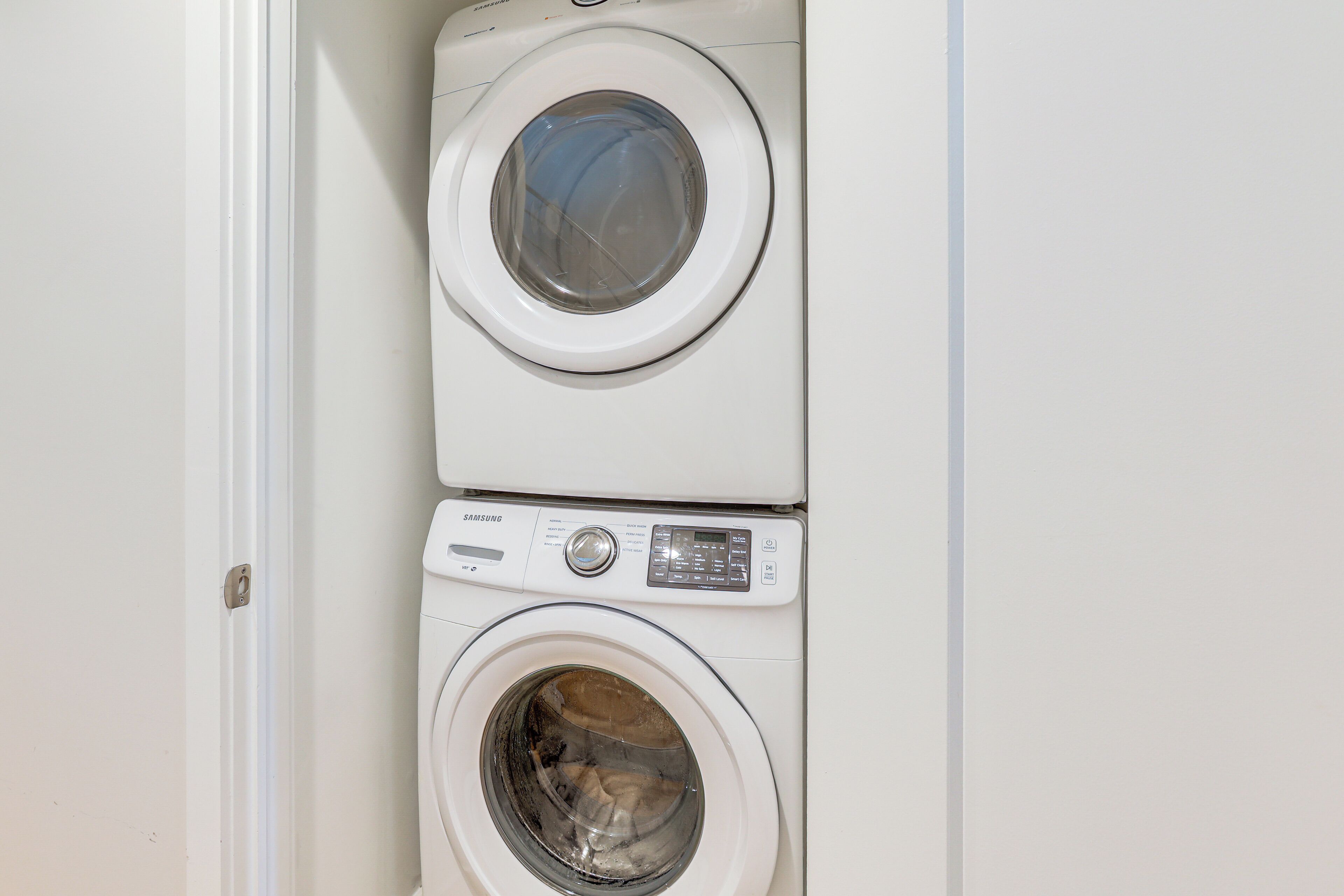 A stacked washer and dryer unit with a control panel and a door.