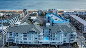 Een hotel aan de kust met meerdere gebouwen, een zwembad en uitzicht op het strand.