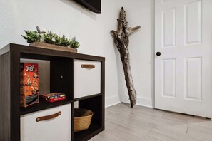 A wooden cabinet with drawers and shelves, a white door, and a piece of driftwood.