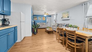Een ruimtelijke woonkamer met een keuken, eethoek en zithoek.