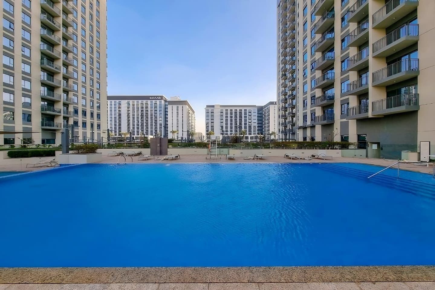 A swimming pool surrounded by high-rise residential buildings with balconies.