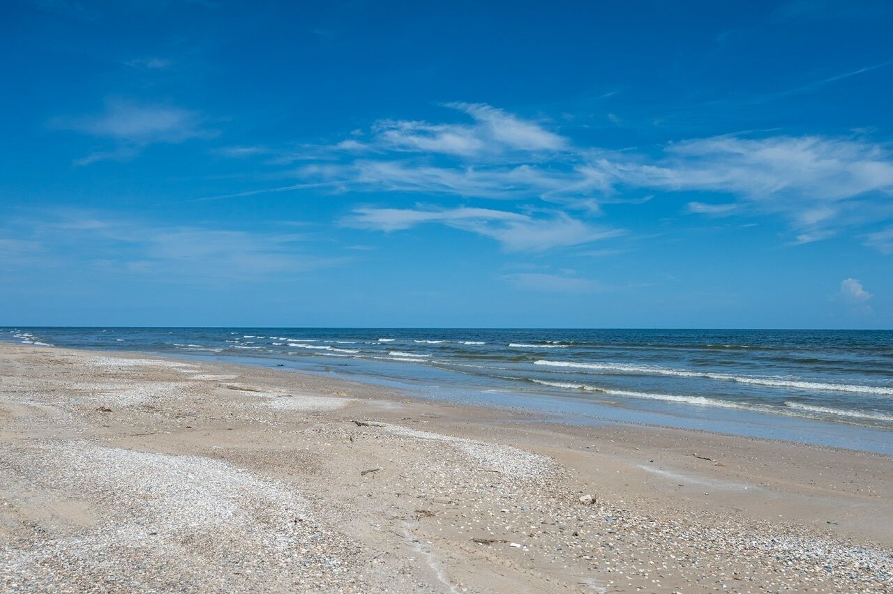 A beach with a clear sky and calm sea.