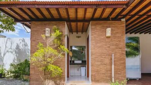 A modern building with a wooden roof and a covered entrance. - Livia Cristina  (Barra de Santo Antônio)