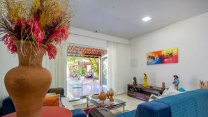 A modern living room with a large vase, a sofa, a coffee table, and a painting on the wall. - Livia Cristina  (Barra de Santo Antônio)