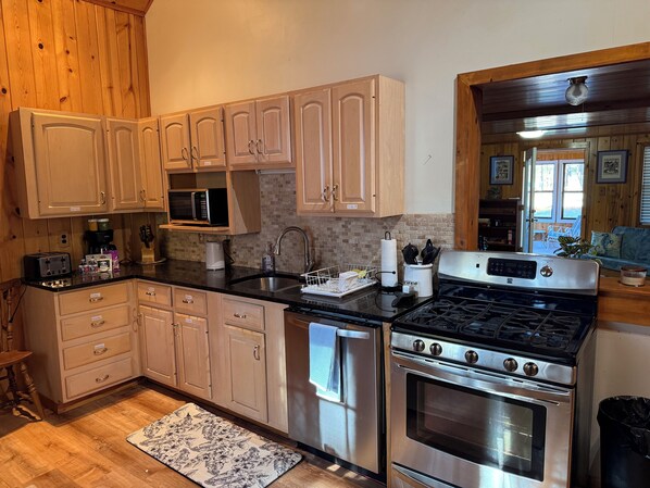 A kitchen with wooden cabinets, a stainless steel stove, and a microwave.
